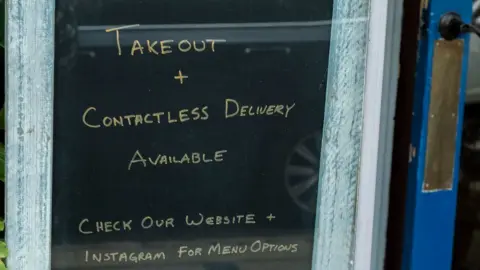 Corbis A sign outside a restaurant in New Jersey offering takeaway and contactless delivery services during the coronavirus lockdown
