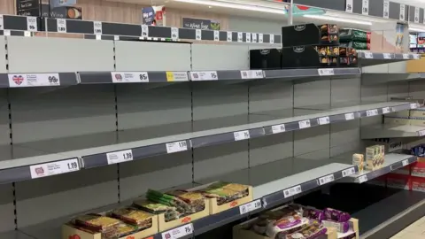 PA Media Empty shelves in a supermarket