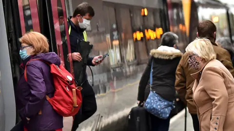 Getty Images People make their way on and off a train at Stoke-on-Trent Train Station on 20 May 2021 in Stoke, England