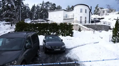 Getty Images A large detached house with two black cars in the foreground