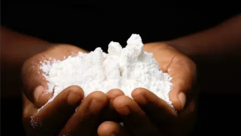 Getty Images Close-up of an African woman´s hands holding maize flour
