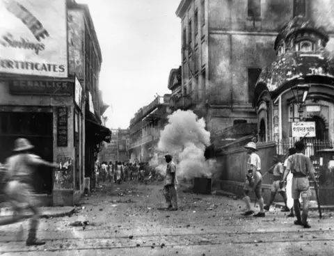 Getty Images Policemen use tear gas bombs during the communal riots in Kolkata (Calcutta) ahead of Partition