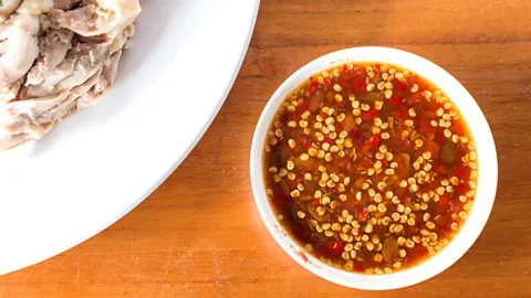 Sermsak Sukwajikhlong/Alamy Small dipping bowls of chilli sauce accompany chicken rice (Credit: Sermsak Sukwajikhlong/Alamy)