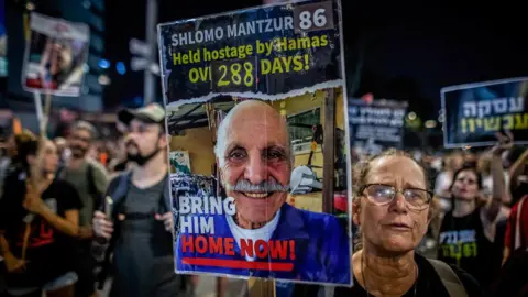Getty Images  An Israeli woman holds a placard showing Shlomo Mantzur