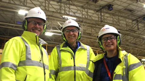 George King/BBC Three Sizewell B employees wearing hard hats and high vis jackets standing next to each other while looking into the camera