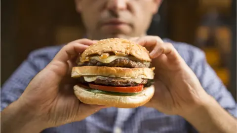 Getty Images Person holding a burger