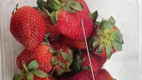 QUEENSLAND POLICE A needle next to strawberries