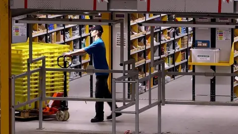 Getty Images An employee moves stock in an Amazon warehouse