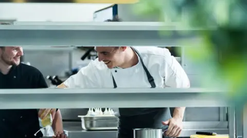 Peers Communications Andrew Sheridan and staff member working in the kitchen at Sosban in Llanelli