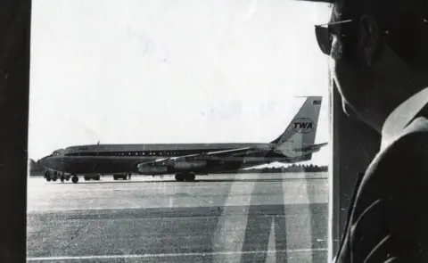 Bangor Daily News Airline official Norman Kaye looks out at hijacked TWA85 at Bangor airport, Maine