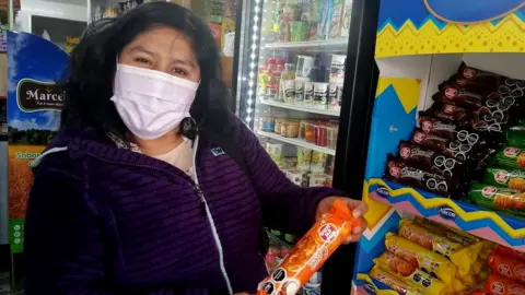 BBC Rosa Cayso Phocco holds a packet of biscuits with a warning label in Chile
