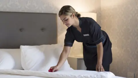 Getty Images Chambermaid making up hotel room