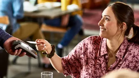 Getty Images Woman paying for meal