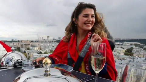 Getty Images A diner sits at a Sky Table suspended 50 metres in the air by crane in Khamovniki, as part of the Dining In The Sky experience