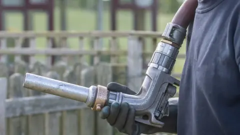 Getty Images Heating oil delivery - pipework and nozzle from the oil tanker- delivery to a residential property