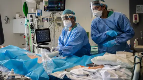 Getty Images Doctors treating a Covid patient in ICU