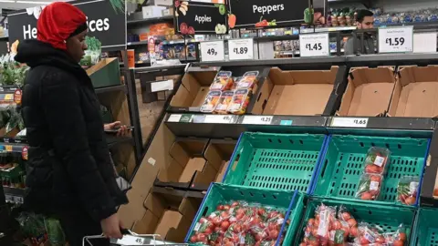 EPA Woman looking at tomatoes in supermarket
