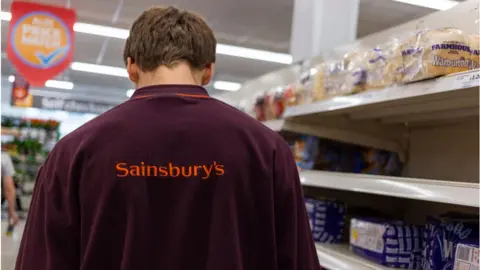 Getty Images Sainsbury's worker in bread aisle