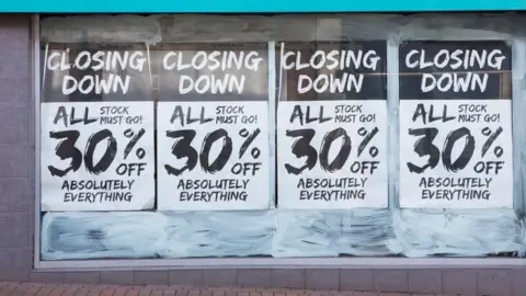 Getty Images Closing signs on shop