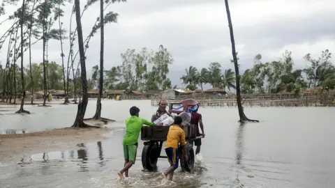 EPA Bangladeshi people walk with their belongings towards a safer area near the coast at the Cox's Bazar district in Chittagong, 30 May 2017