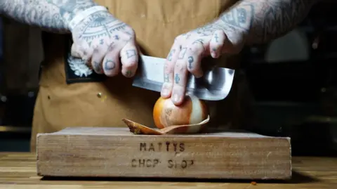@ollierosserphoto A close up of Matt O'Brien chopping in his kitchen