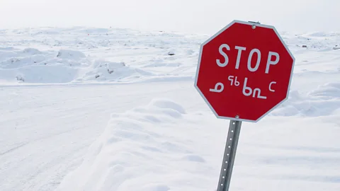 Alamy When they were educated using the Inuktitut alphabet, shown on a stop sign in Nunavut here, Inuit children were ahead of their peers taught in English or French (Credit: Alamy)