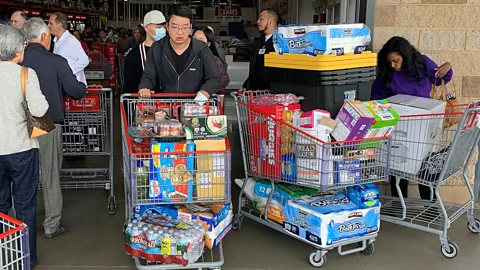 Getty Images Customers in Los Angeles stock up on food, water and toilet paper on 29 February. Herd mentality is one of the key causes of panic buying (Credit: Getty Images)