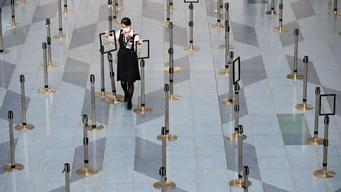 Getty Images Tokyo's Haneda Airport in March as the coronavirus spread across the globe. Though much emptier, social distancing is in full effect at airports (Credit: Getty Images)
