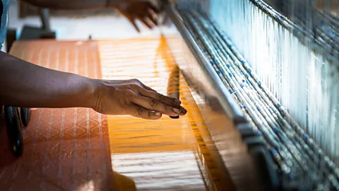 Joerg Drescher/Getty Images Ikat weaving from Cambodia's unique golden silk dates back more than 1,000 years to the Khmer Empire (Credit: Joerg Drescher/Getty Images)
