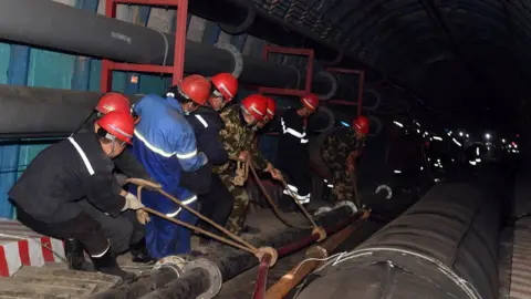 Reuters Rescuers work at the site where a coal mine flooded in Hutubi county