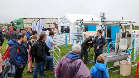 CALLUM STALEY/CSJ PHOTOGRAPHY People watching a milking demonstration