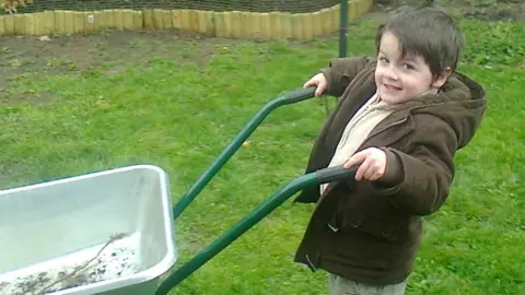 Craig Mathieson Cameron Mathieson pushes a wheelbarrow