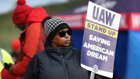 Getty Images Workers picket outside the Ford Assembly plant in Chicago during the UAW strike against the Big Three US car makers on 10 October, 2023.